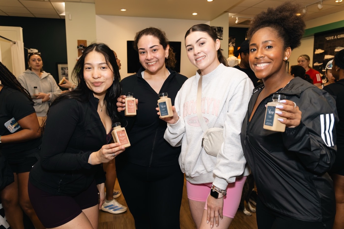 Four runners holding Silk Road bottled lattes after the adidas Run Club run at West Stride