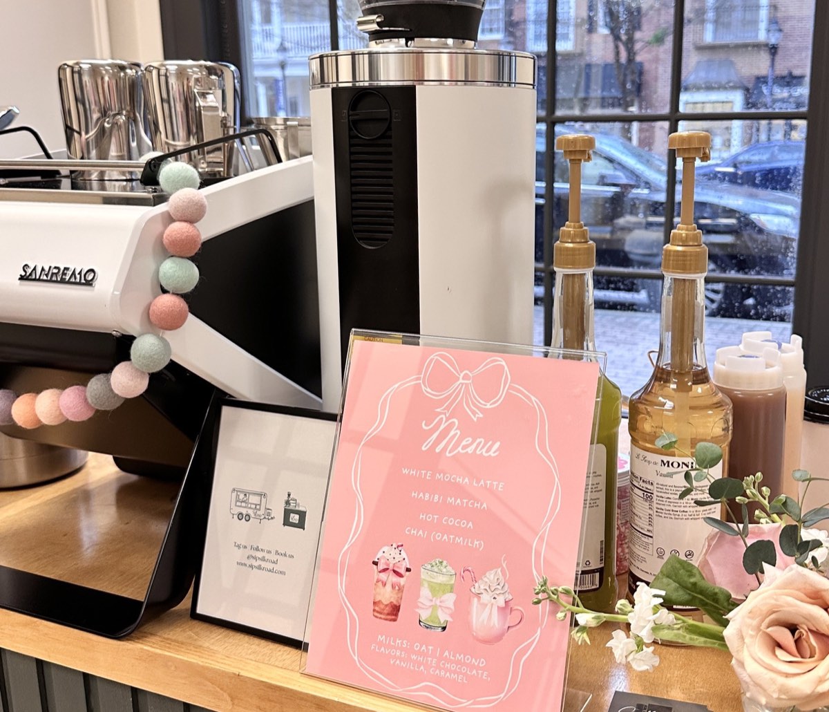 The Silk Road bar set for a private event: espresso machine, a custom menu card and flowers